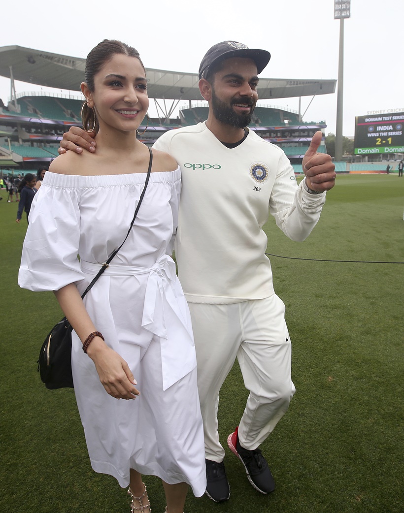 India's cricket captain Virat Kohli, right, walks with his wife, Anushka Sharma celebrates India's series win over Australia after play was called off on day 5 of their cricket test match in Sydney