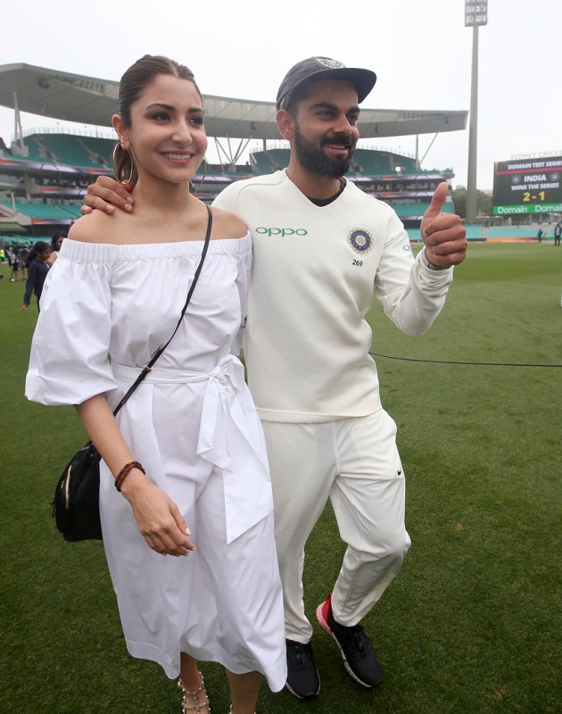 India's cricket captain Virat Kohli, right, walks with his wife, Anushka Sharma celebrates India's series win over Australia after play was called off on day 5 of their cricket test match in Sydney
