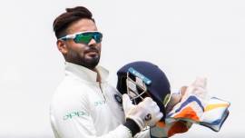 India's wicketkeeper Rishabh Pant holds his helmet during play on day three of the third cricket test between India and Australia in Melbourne, Australia