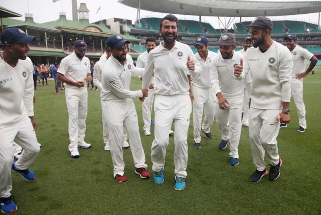 India's Virat Kohli, right, encourages Cheteshwar Pujara, center, as the team dance as they celebrate their series win over Australia after play was called off on day 5 of their cricket test match in Sydney