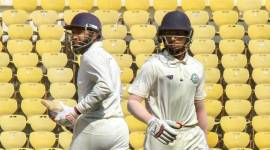Vidarbha batsmen Wasim Jaffar and S R Ramaswamy cross for runs on the second day of the Ranji Trophy quarterfinal cricket match against Uttarakhand, in Nagpur, Maharashtra