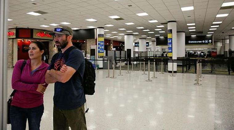 Confused travelers look to find their concourse as they walk past a closed down terminal at the Miami International Airport on Saturday. (AP)