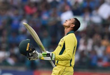 Australian batsman Usman Khawaja raises his bat after scoring his century during the 5th ODI cricket match against India, at Feroz Shah Kotla Cricket Stadium in New Delhi