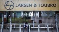 FILE PHOTO: A man waits at a bus-stop with an advertisement of Larsen & Toubro outside the company’s manufacturing unit in Mumbai In light of L&T and Mindtree, a look at how hostile takeover bids have played out over the years