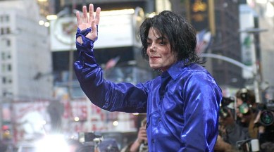 FILE - This Nov. 7, 2001 file photo, Michael Jackson waves to crowds gathered to see him at his first ever in-store appearance in New York. The producers of “The Simpsons” are removing a classic episode that featured the voice of Michael Jackson. Executive producer James L. Brooks told The Wall Street Journal on Thursday, March 7, 2019, “it feels clearly the only choice to make.” He said fellow executive producers Matt Groening and Al Jean are “of one mind on this.” (AP Photo/Suzanne Plunkett)