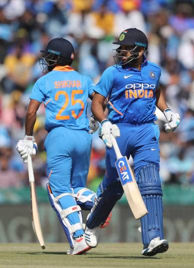 India's Rohit Sharma, right, and Shikhar Dhawan run between the wickets to score during the fourth one day international cricket match between India and Australia in Mohali