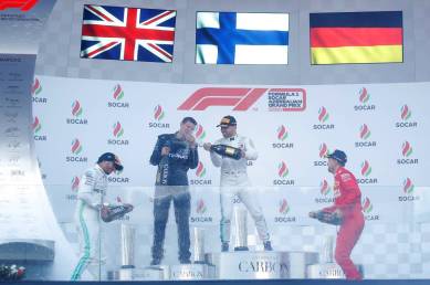 Mercedes' Valtteri Bottas celebrates winning the race with Mercedes mechanic Stuart Green, second placed Lewis Hamilton and third placed Ferrari's Sebastian Vettel on the podium