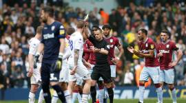 Referee Stuart Attwell shows yellow card during Leeds United vs Aston Villa