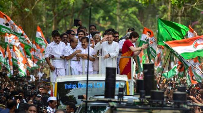 Wayanad: Congress President Rahul Gandhi along with party General Secretary and Uttar Pradesh - East in charge Priyanka Gandhi Vadra and other leaders wave at party supporters during a roadshow ahead of the former's nomination filing, ahead of the Lok Sabha elections, in Wayanad, Thursday, April 4, 2019. (PTI Photo/Shailendra Bhojak)(PTI4_4_2019_000066A)