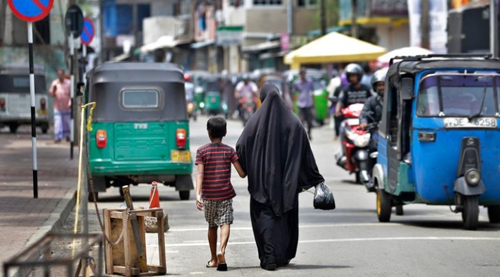 A woman returns from the market with her son in Colombo Monday. (AP)