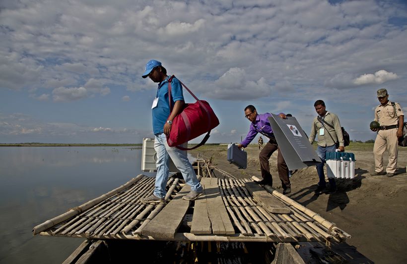 Election officials sail boats, trek hills to carry voting machines