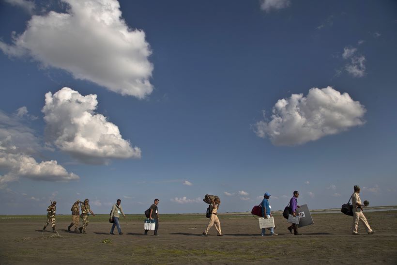 Election officials sail boats, trek hills to carry voting machines