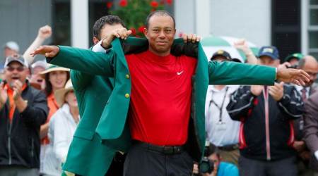 FILE PHOTO: Patrick Reed places the green jacket on Tiger Woods of the U.S. after Woods won the 2019 Masters in Augusta, Georgia, U.S., April 14, 2019. REUTERS/Brian Snyder/File Photo