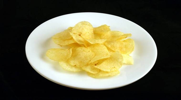 A worker sorts fried crinkle-cut potato chips as they move along a News  Photo - Getty Images