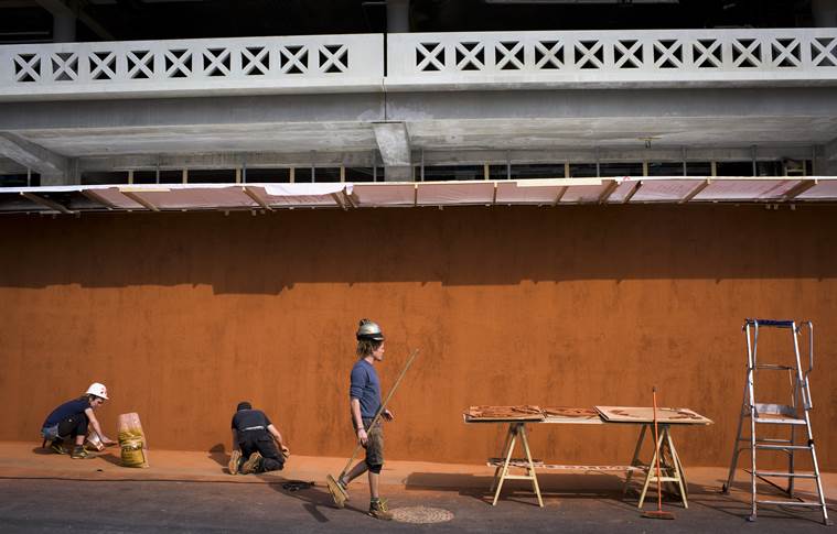 Construction workers work on a wall adjacent to Philippe Chatrier Court
