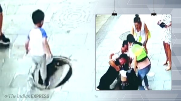 father saves child falling in manhole, uncovered manhole viral video, kid falls in manhole viral video, trending, indian express, indian express news