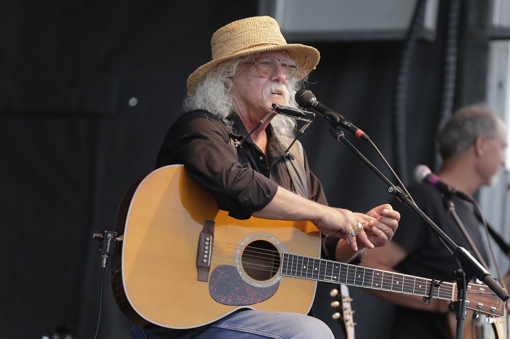 Arlo Guthrie talks during a concert at a Woodstock 50th anniversary event