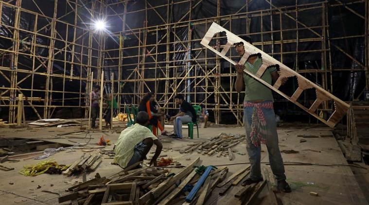 Work in progress at the Pandal of Kashi Bose Lane Durga Puja Samity in North Kolkata, Members are inspecting the area which is still uncovered from media. .Express photo by Partha Paul
