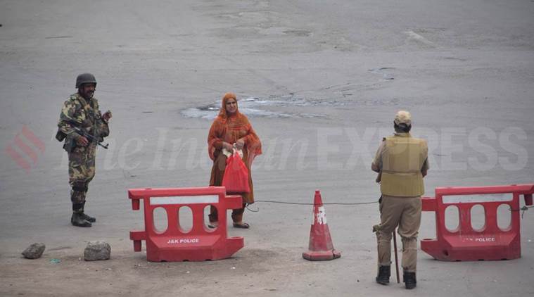 Armed security personnel guard a street in Srinagar where curfew has been imposed by the administration. Express Photo by Shuaib Masoodi