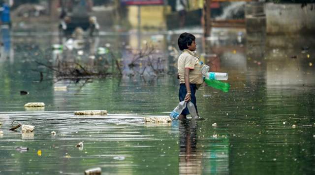 Patna: A rag picker collects plastic drinking bottles floating on floodwaters after water levels receded at Rajendra Nagar area, in Patna, Sunday, Oct. 06, 2019. (PTI Photo)(PTI10_6_2019_000086B)