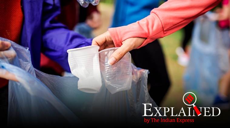 A midsection of group of fit young people picking up litter in nature, a plogging concept.