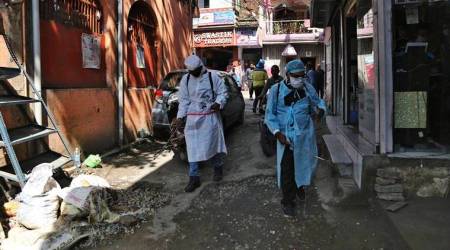 Indian health workers spray disinfects as a precaution against COVID-19 in Jammu, India, Monday, March 16, 2020. For most people, the new coronavirus causes only mild or moderate symptoms. For some, it can cause more severe illness, especially in older adults and people with existing health problems. (AP Photo/Channi Anand)