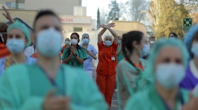 Health workers applaud as people react from their houses in support of the medical staff that are working on the COVID-19 virus outbreak at the Gregorio Maranon hospital in Madrid, Spain, Wednesday, April 1, 2020. The new coronavirus causes mild or moderate symptoms for most people, but for some, especially older adults and people with existing health problems, it can cause more severe illness or death. (AP Photo/Manu Fernandez)