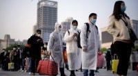Travellers line up with their belongings outside Hankou Railway Station in Wuhan coronavirus, coronavirus update, china lockdown, wuhan lockdown, china coronavirus, china news, coronavirus latest update, coronavirus global update, world news, indian express