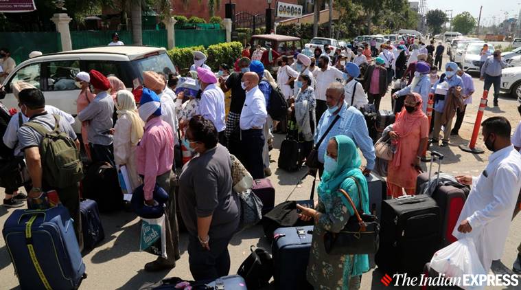 A US embassy official gives instructions to a batch of NRIs being taken to the US in relief flights. The NRIs were shuttled in buses from Ludhiana to the Delhi airport on Friday