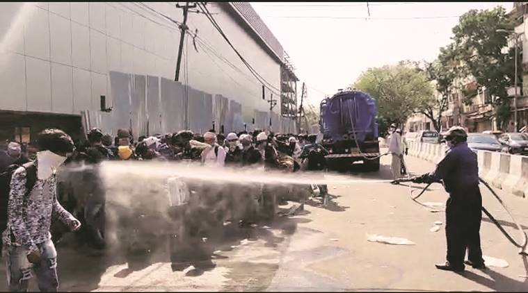 delhi lockdown, delhi migrant labourers, delhi coronavirus, delhi migrants sprayed with disinfectant, delhi city news, Lajpat Nagar migrants sprayed with disinfectant