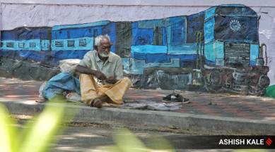 With no transport available, a migrant walking back home rests on a footpath in Pune on Thursday. (Express Photo: Ashish Kale)