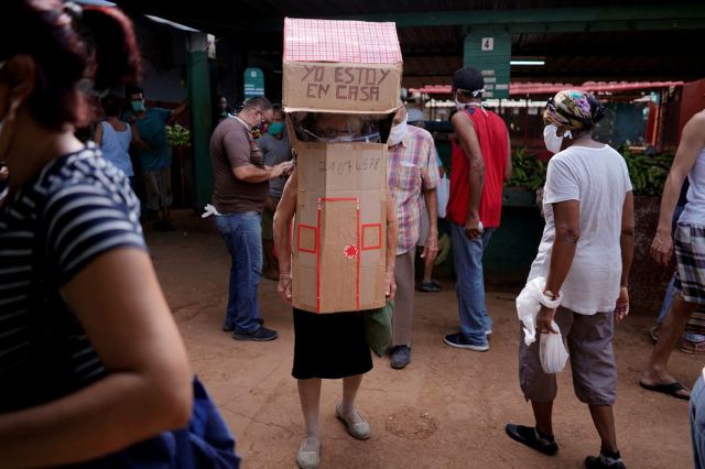 Retired nurse Feridia Rojas, 82, wears cardboard shaped into a house at a market to protect herself from the spread of the coronavirus disease (COVID-19) outbreak, in Havana, Cuba, June 11, 2020. 