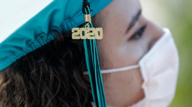 Valedictorian Sierra Morgado's graduation tassel has "2020" on it as she listens during a graduation ceremony for the senior class of Chambers High School at Homestead-Miami Speedway, Tuesday, June 23, 2020, in Homestead, Fla. Forty-one seniors graduated from the school and crossed the start-finish line to receive their diplomas, during the coronavirus pandemic. (AP Photo/Wilfredo Lee)