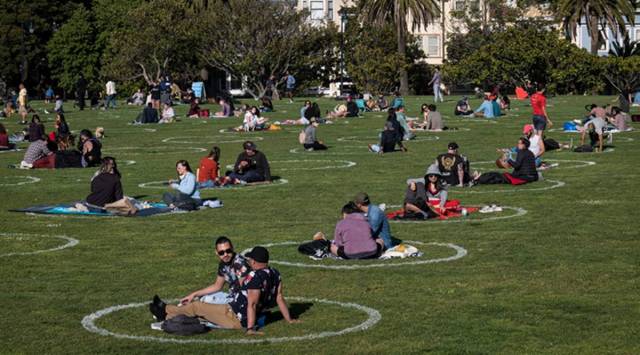 People lay on the grass in circles drawn to promote social distancing at Dolores Park in San Francisco, California, U.S., on Thursday, May 21, 2020.  Photographer: David Paul Morris/Bloomberg