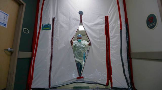 A doctor slips through a makeshift door at a covid health centre in Texas (AP)