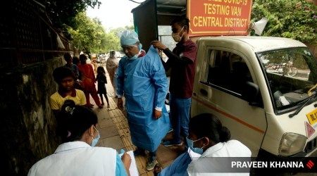 A health worker getting ready to conduct Covid-19 tests in Delhi. (Express Photo: Praveen Khanna)