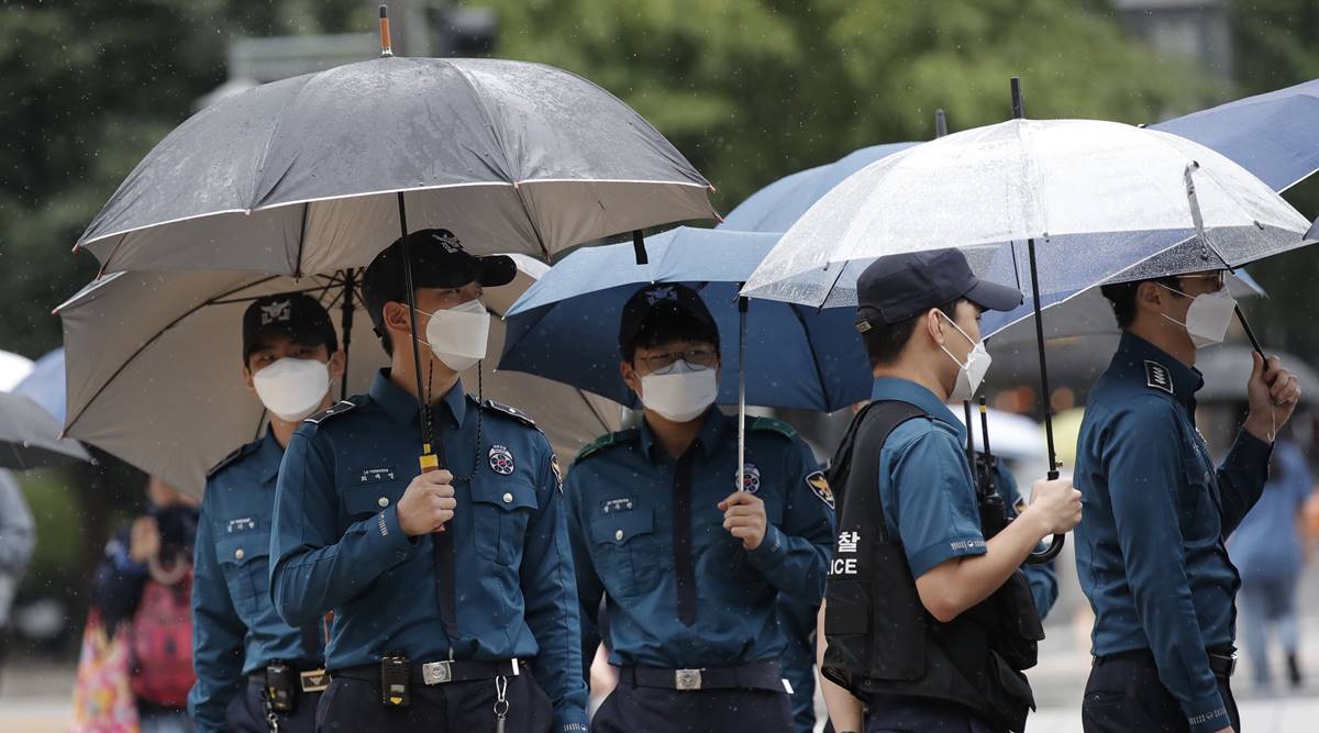 Police officers wearing face masks to help protect against the spread of the coronavirus, walk in downtown Seoul, South Korea (AP)