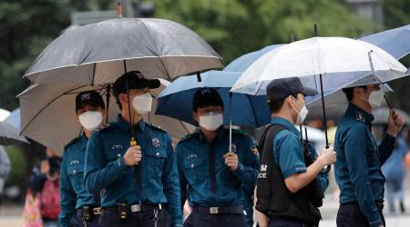 Police officers wearing face masks to help protect against the spread of the coronavirus, walk in downtown Seoul, South Korea (AP)
