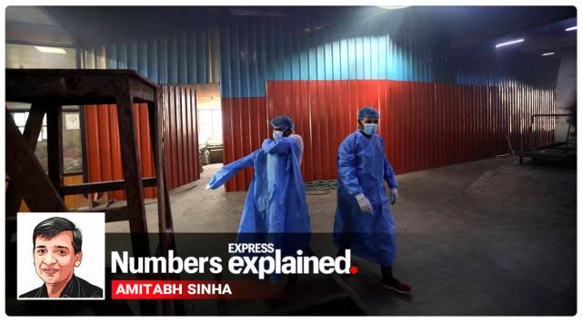 Workers put on personal protective suits before carrying the body of a COVID-19 victim for cremation in New Delhi (AP)