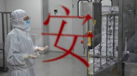 A worker stands near the word for Safety as she monitors production of SARS CoV-2 Vaccine for COVID-19 at a SinoVac factory in Beijing (AP Photo/Ng Han Guan)