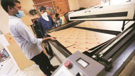 A workshop in a lane cuts glass to stand between Delhi power corridors, virus