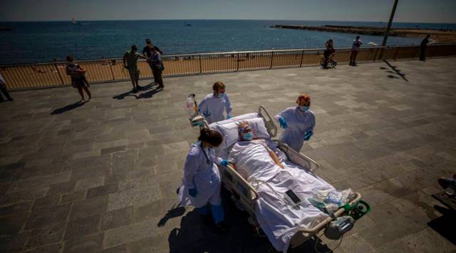 Francisco España, 60, is transported back to the hospital after spending a few minutes by the promenade, in Barcelona, Spain, Friday, Sept. 4, 2020. (AP Photo/Emilio Morenatti)