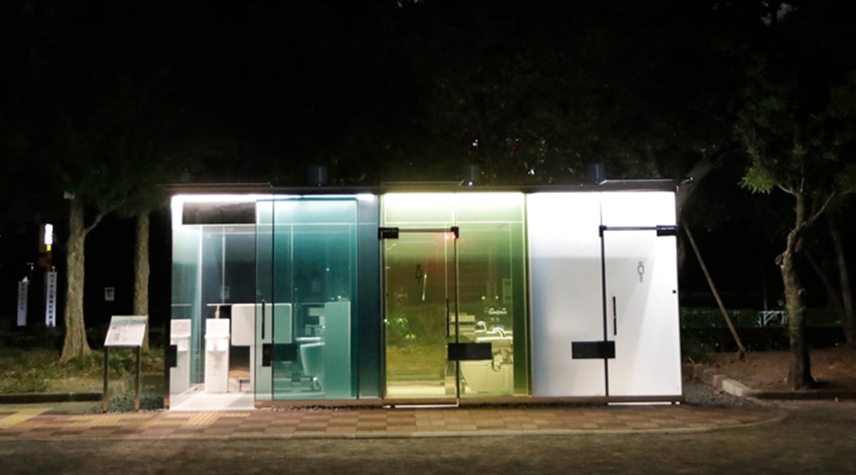 A man uses a transparent toilet that has turned opaque, right, after the door was locked at Haru-no-Owaga Community Park in Tokyo on Thursday, Aug. 27, 2020. (AP)