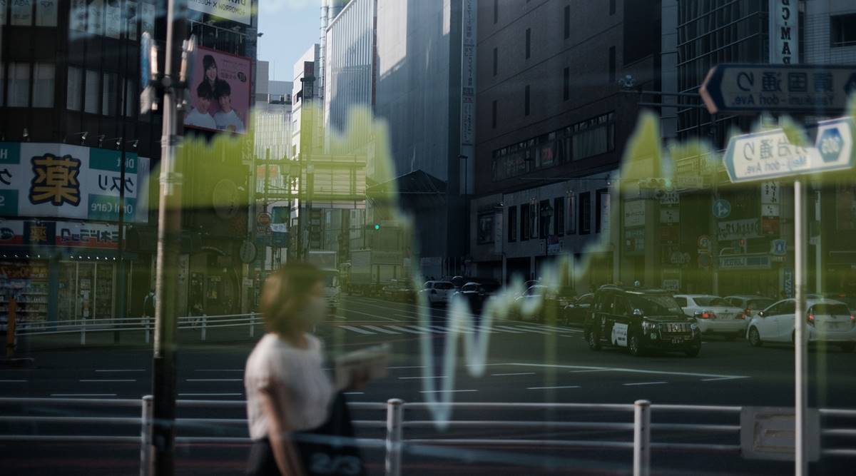 A pedestrian is reflected on an electronic stock board outside a securities firm in Tokyo, Japan, on Friday, Aug. 28, 2020. (Photographer: Soichiro Koriyama/Bloomberg)