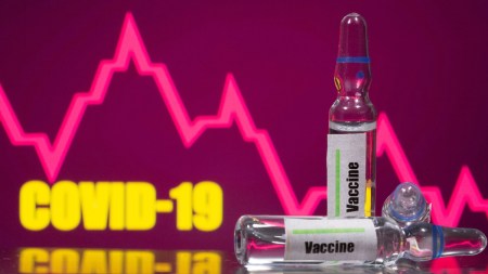A test tube labelled with the Vaccine is seen in front of Covid-19 and stock graph logo in this illustration taken, September 9, 2020. (Reuters)