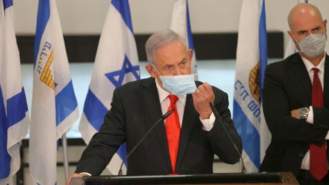 Israeli Prime Minister Benjamin Netanyahu adjusts his face mask during his visit to the Israeli city of Beit Shemesh, near Jerusalem, Tuesday, Sept. 8, 2020. Beit Shemesh, along with other towns with large populations of ultra-Orthodox Jews, has experienced high infection rates of the coronavirus and is on a list of communities with overnight curfews. (Alex Kolomoisky/Pool Photo via AP)