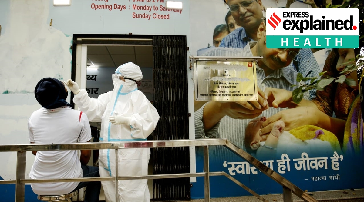 A health worker takes swab sample at Mohalla Clinic in New Delhi on Wednesday (Express photo by Praveen Khanna)