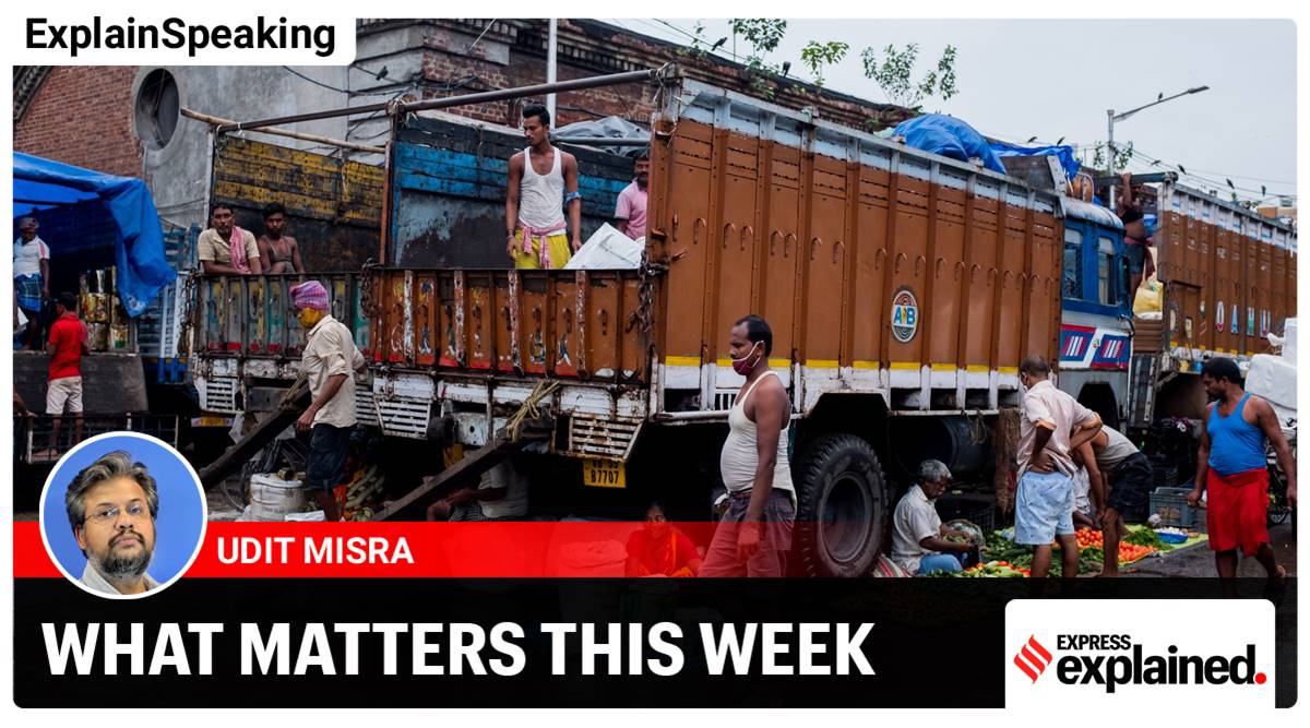 Vendors sell fruit and vegetables next to trucks in the Burrabazar area of Kolkata 