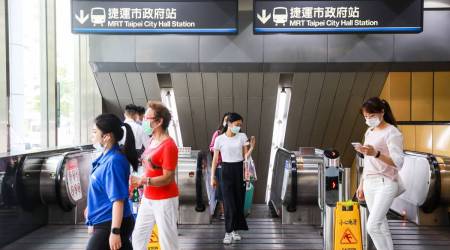 People wearing protective masks exit Taipei City Hall station in Taipei, Taiwan