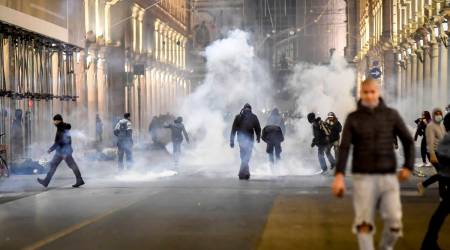 Smoke billows as clashes broke out during a protest against the government restriction measures to curb the spread of COVID-19 in Turin, Italy,  (AP)
